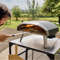 person turning pizza in the Ooni koda 16 using a ooni turning peel. 